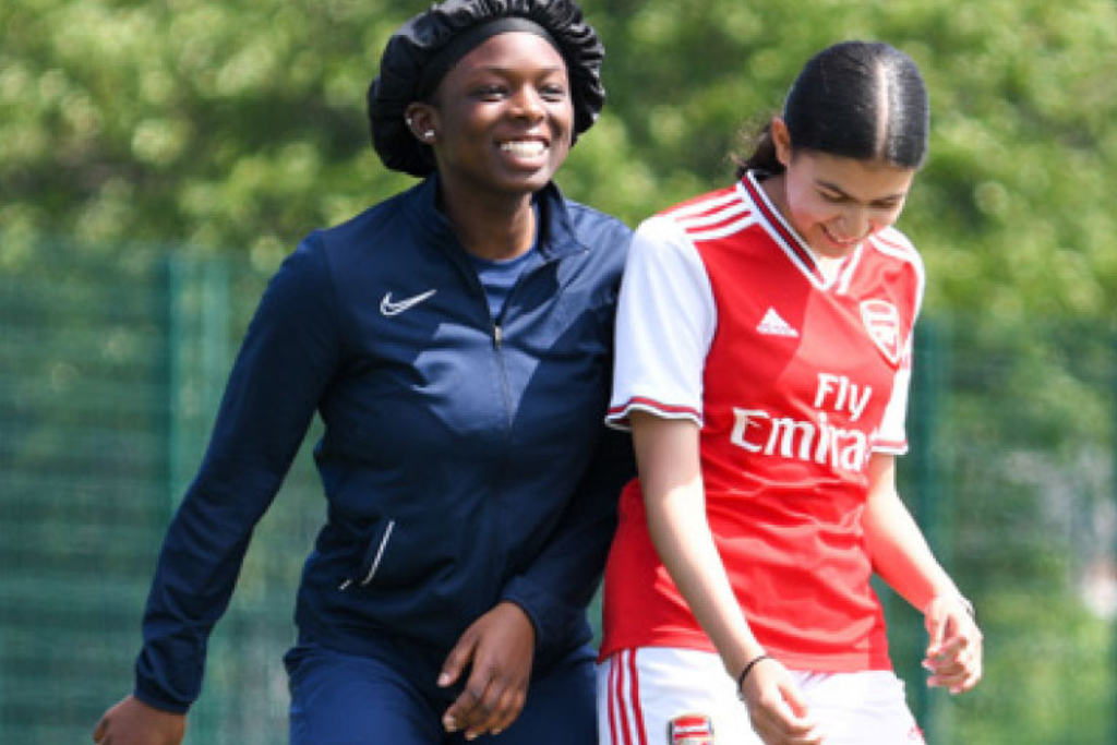 A photo of Osiro Imoedemhe and a younng player from the Arsenal Girls Kicks Programme