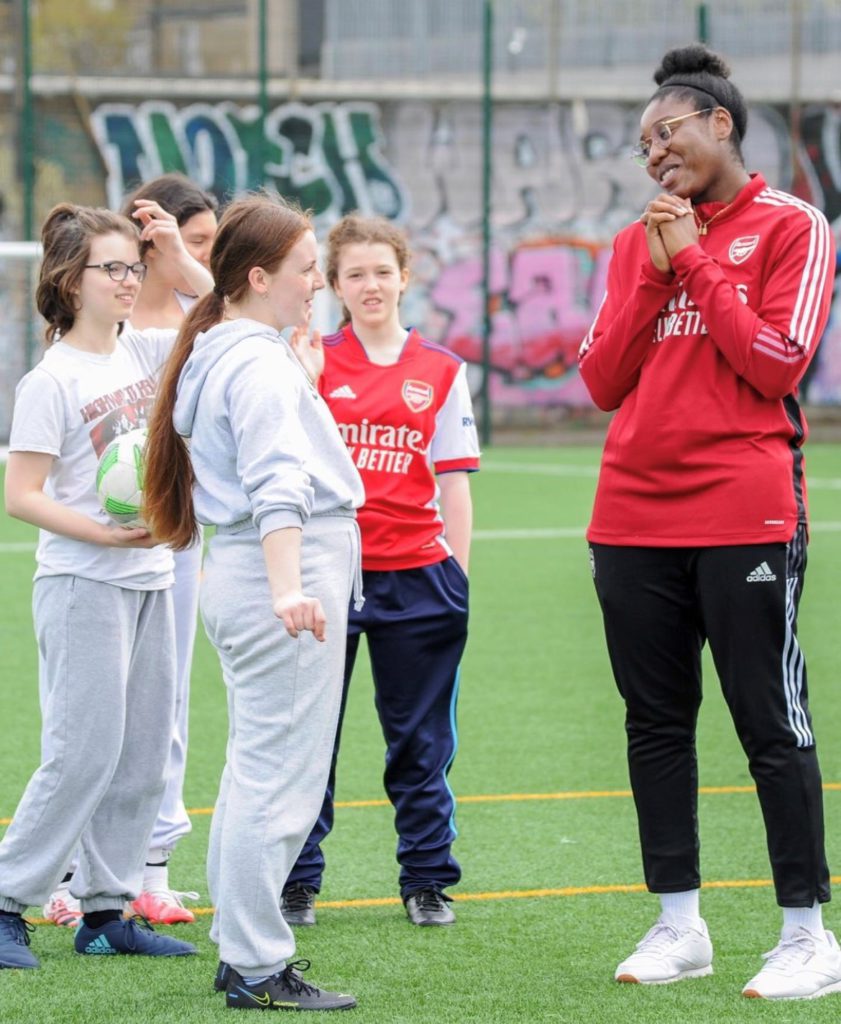 An image of Osiro and young girls at Arsenal Girls Kicks